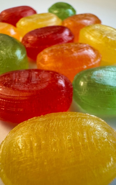 a row of colourful hard booiled candies in yellow, red, green, orange
