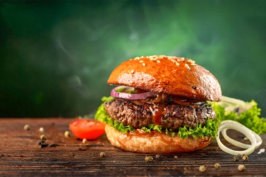 A hearty hamburger with lettuce and tomatoes.