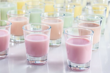 Rows of shot glasses with colourful liquids ready for tasting