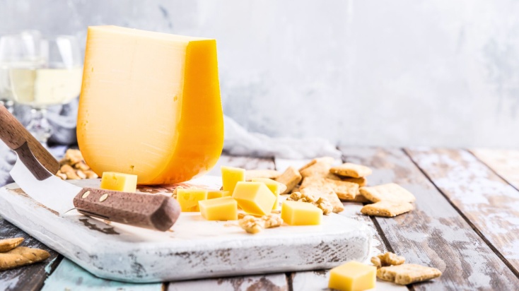 Cheese wedge and cubes on a cutting board