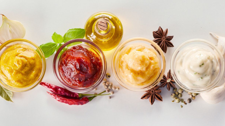 A variety of creamy sauces in small white bowls.