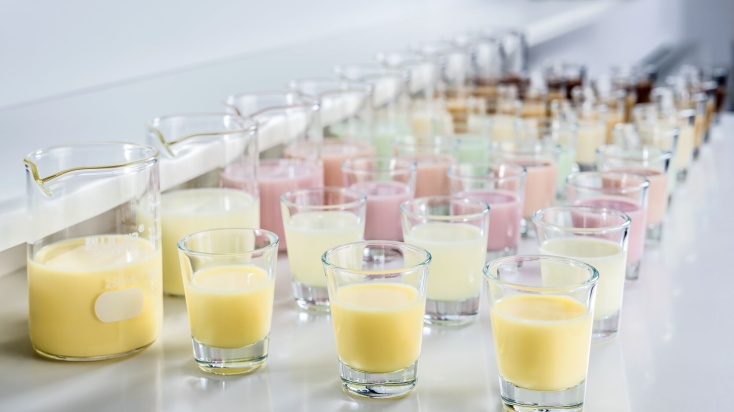 rows of shot glasses with colourful creamy liquid