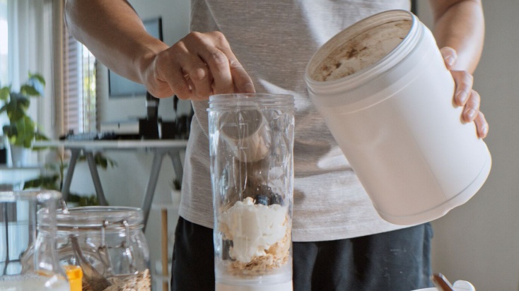 A person preparing a protein shake for breakfast