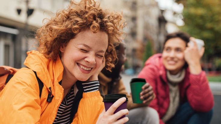 a group of people, having fun, sitting outside with ToGo cups